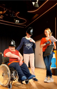 Drei Schauspieler stehen auf der Theaterbühne